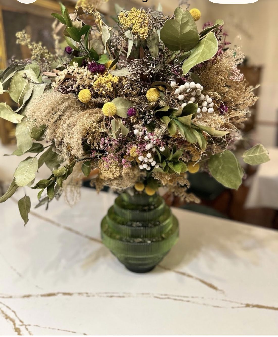 Dried floral arrangement in a green glass vase, grown and dried from Aviva's own garden